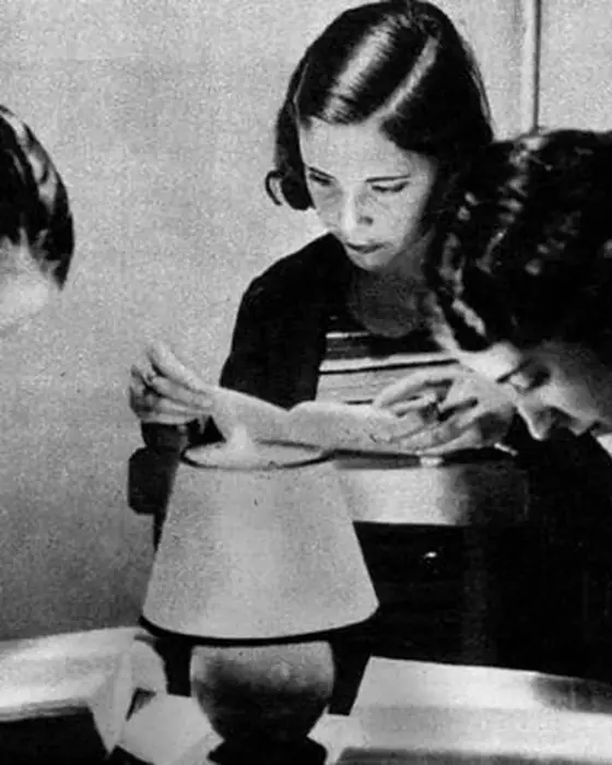 Dos mujeres estudiando bajo una lámpara