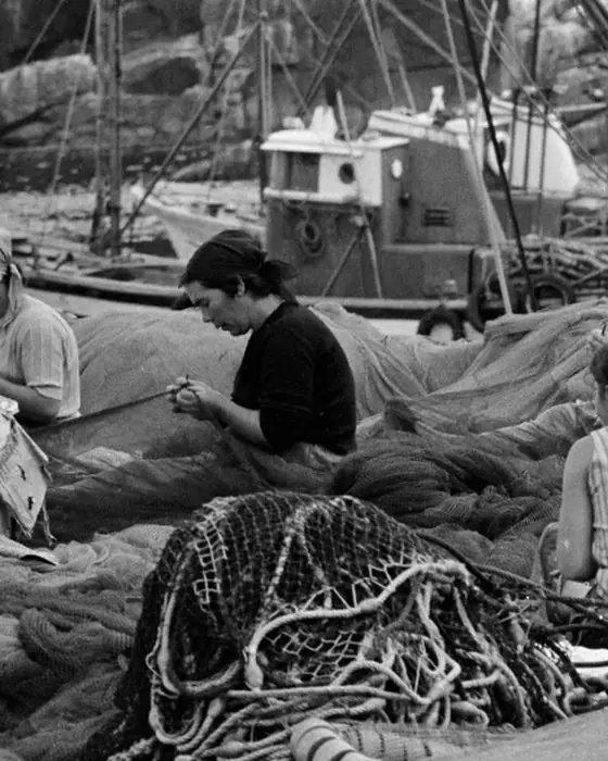 Mujeres remendando redes de pesca en el puerto
