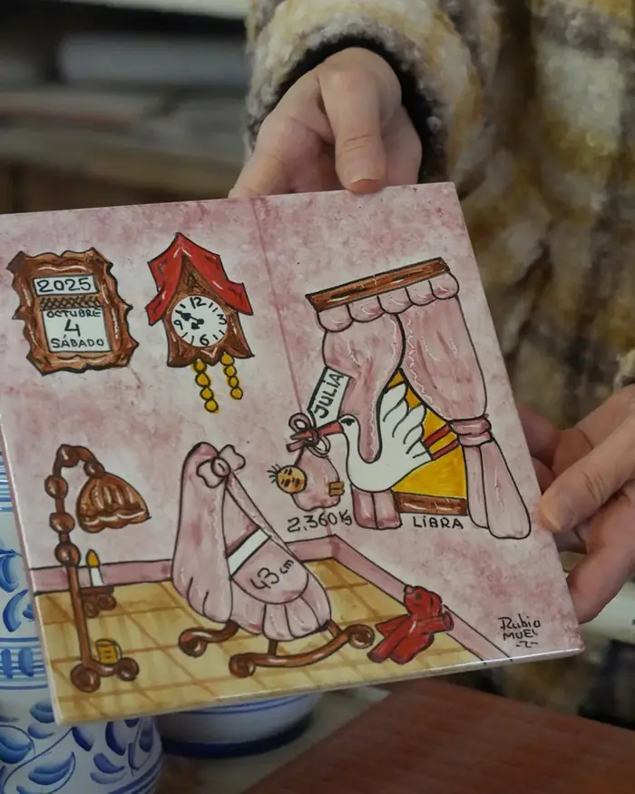 Manos sosteniendo un azulejo pintado a mano